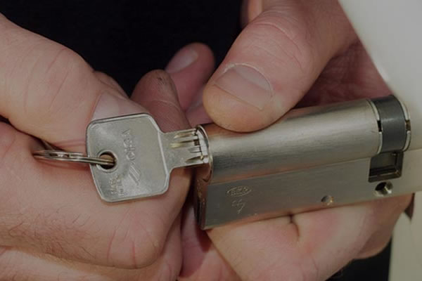Locksmith holding a new euro cylinder lock and key